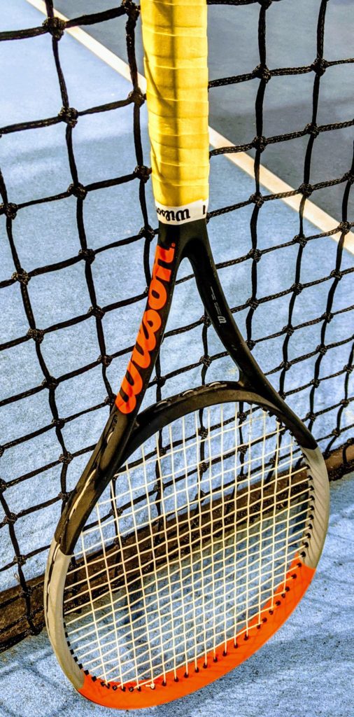 Wilson Clash 100 tennis racquet upright on the tennis court