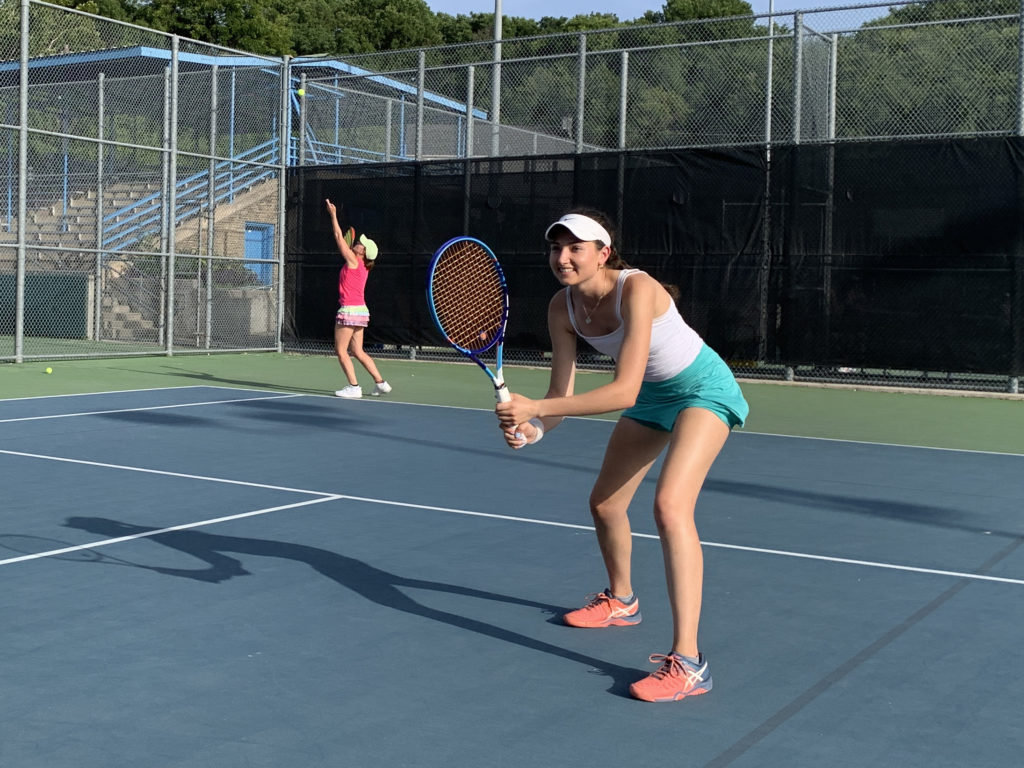 Two women playing doubles in tennis skirts
