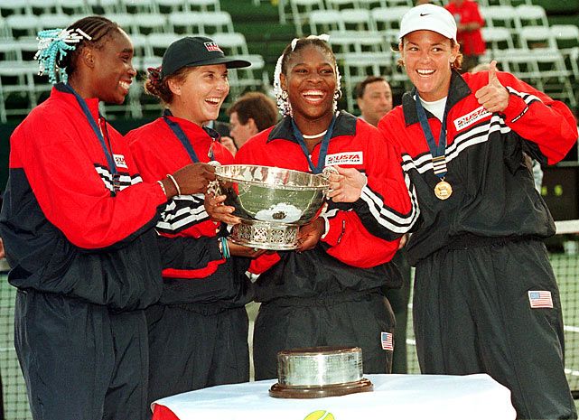 Venus Williams, Monica Seles, Serena Williams, and Lindsay Davenport celebrate winning the 1999 Fed Cup Trophy