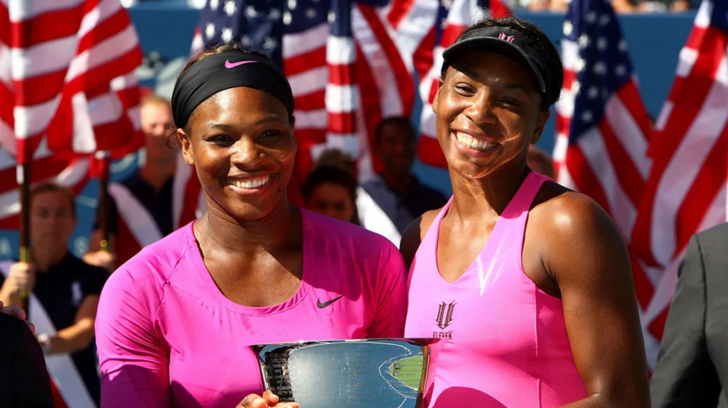 Serena Williams (L) and Venus Williams pose with the championship trophy after defeating Cara Black of Zimbabwe and Liezel Huber in the women’s doubles final on the fifteenth day of the 2009 US Open.