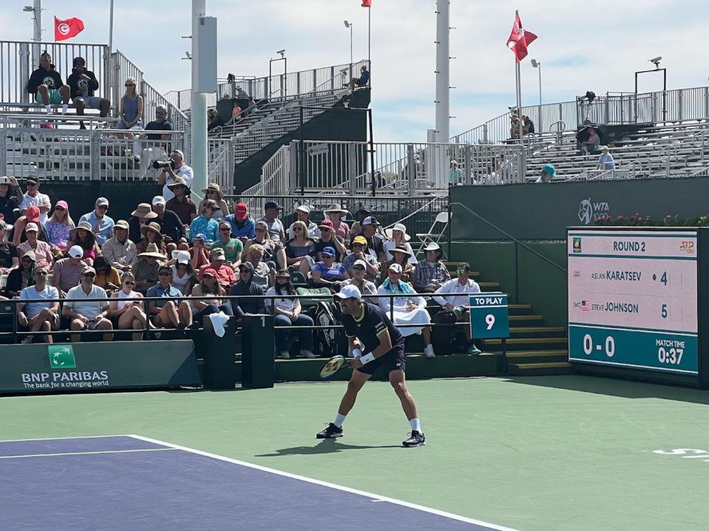 Steve Johnson returning serve in windy conditions against Aslan Karatsev at the 2022 Indian Wells Masters. 